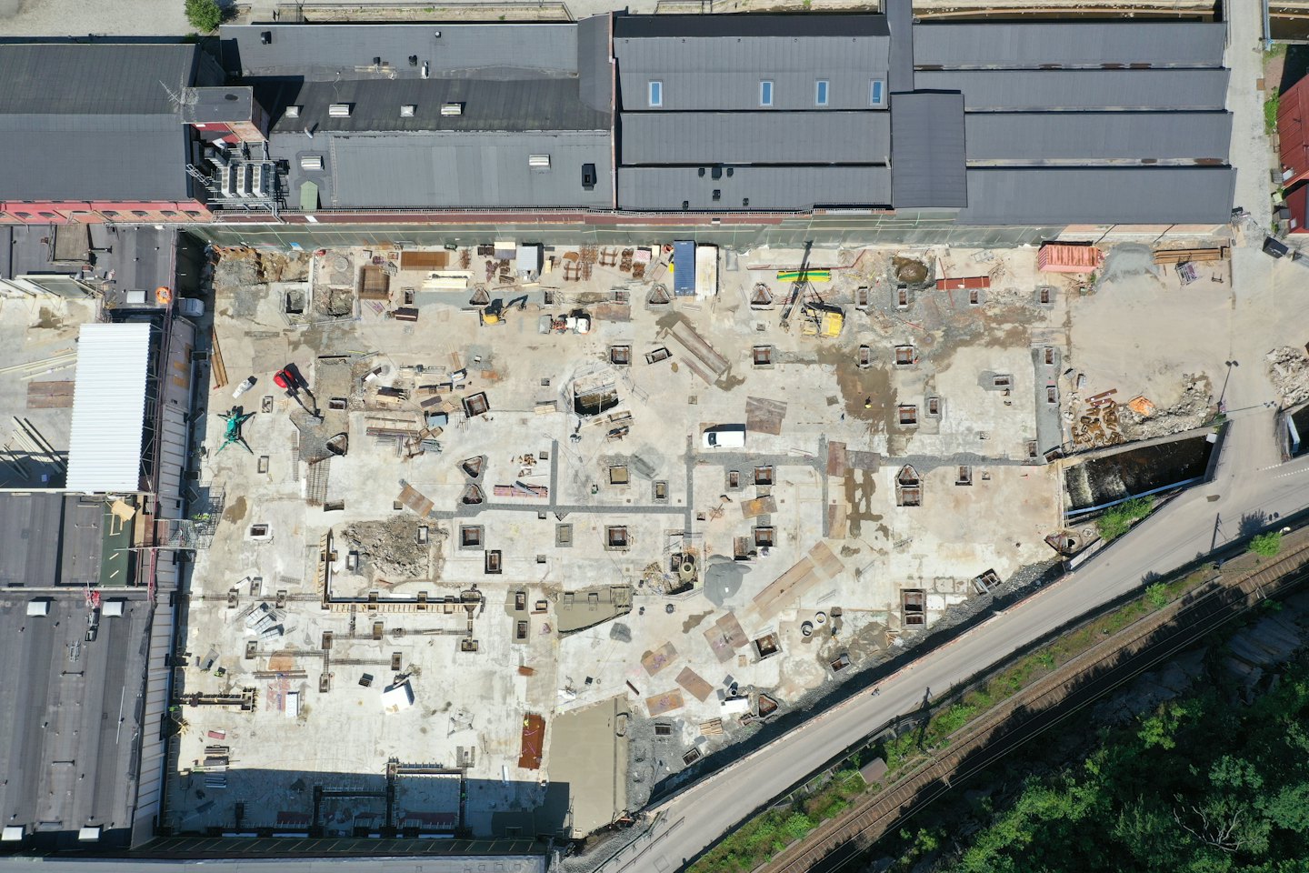 Beton temeller ve yapı malzemeleriyle dolu bir inşaat alanı.